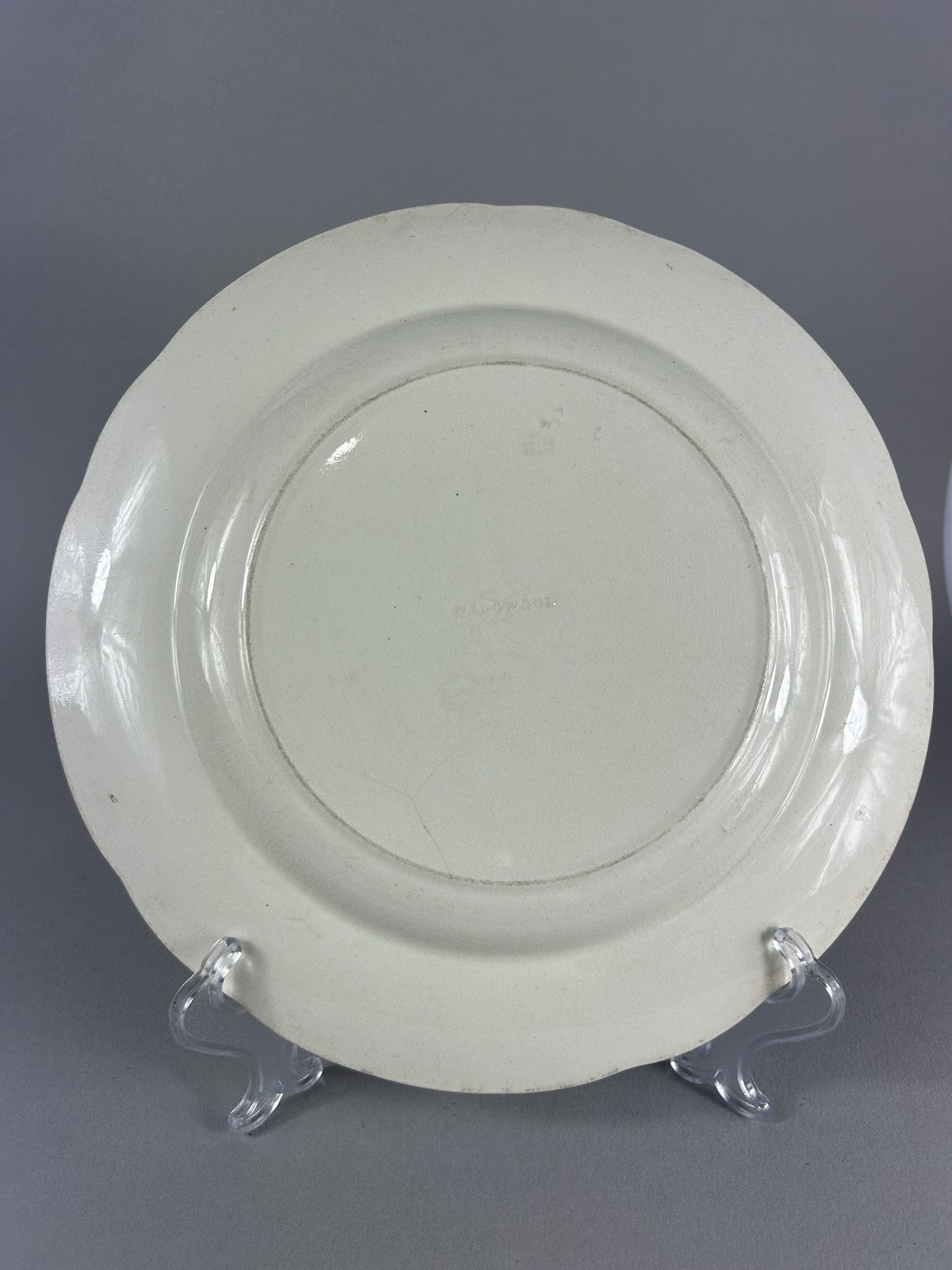 Early Wedgwood creamware plate with moulded putti border, 26cm