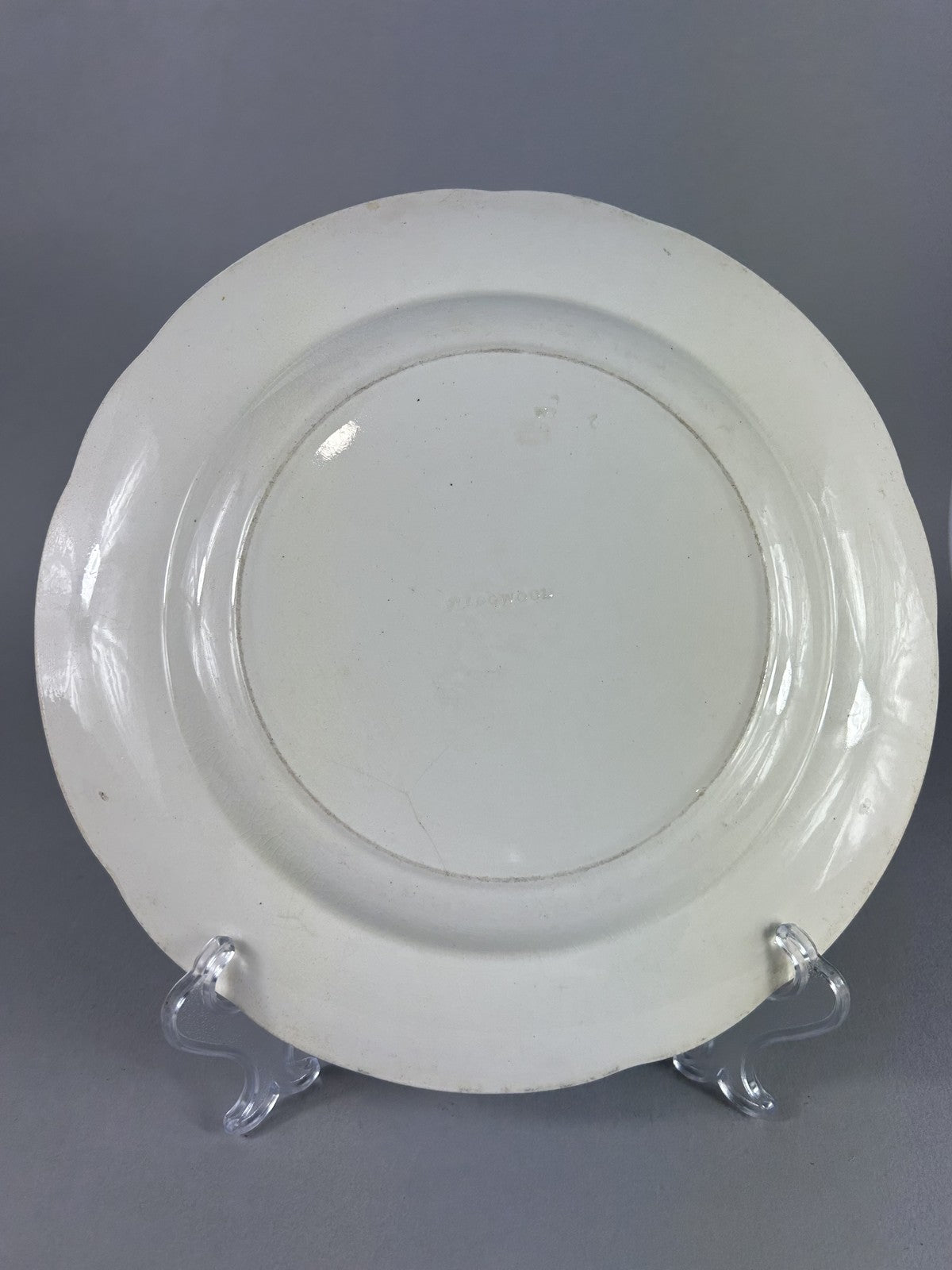 Early Wedgwood creamware plate with moulded putti border, 26cm